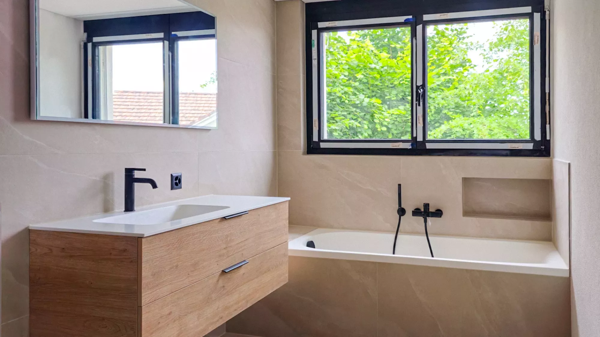 Realisiertes Badezimmer mit Holzwaschtisch und Badewanne am Fenster