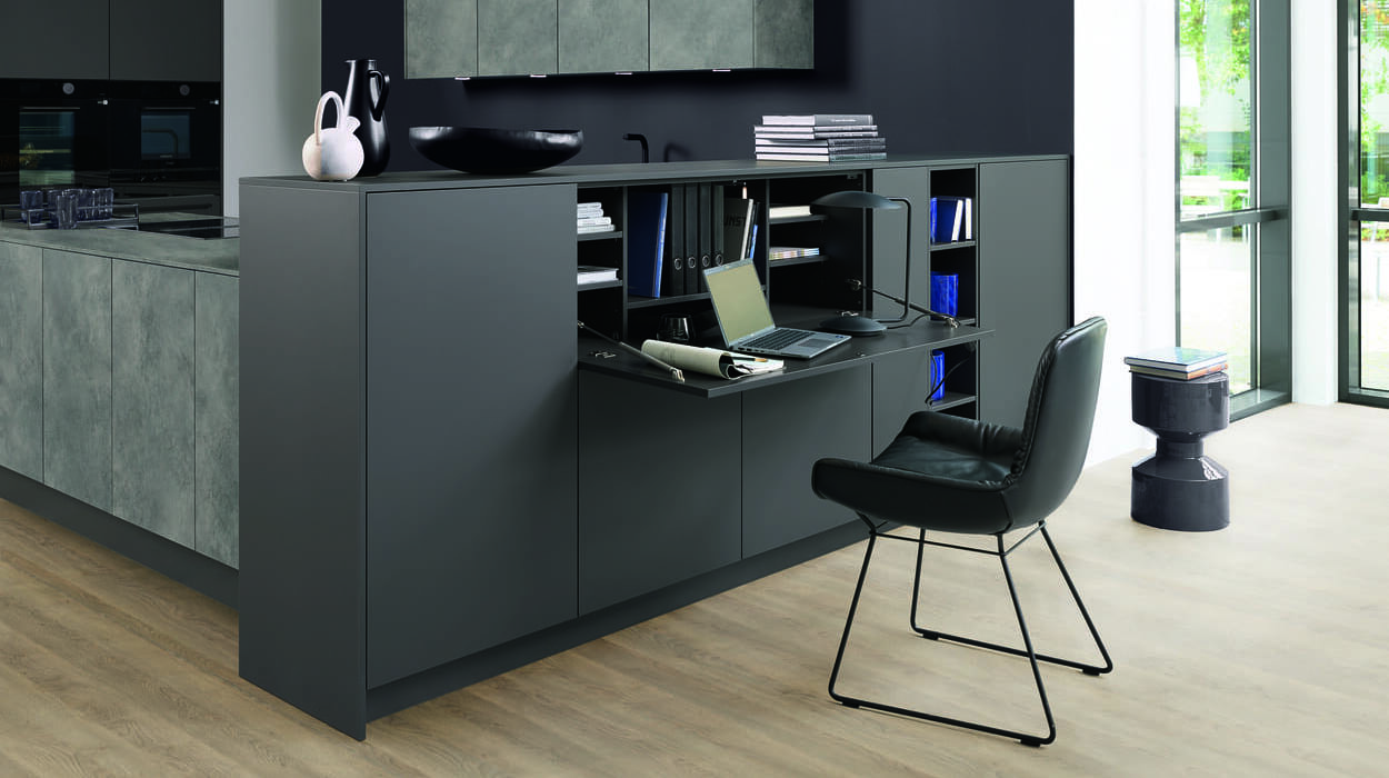 Küche mit integriertem Bürotisch in Anthrazit- und Sandstein-Optik der Fels Küchen-Bäder AG